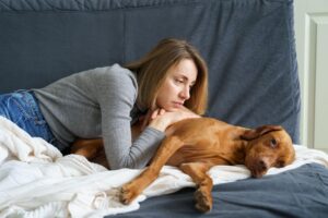 tutora observando seu cão que aparenta está triste ou abatido