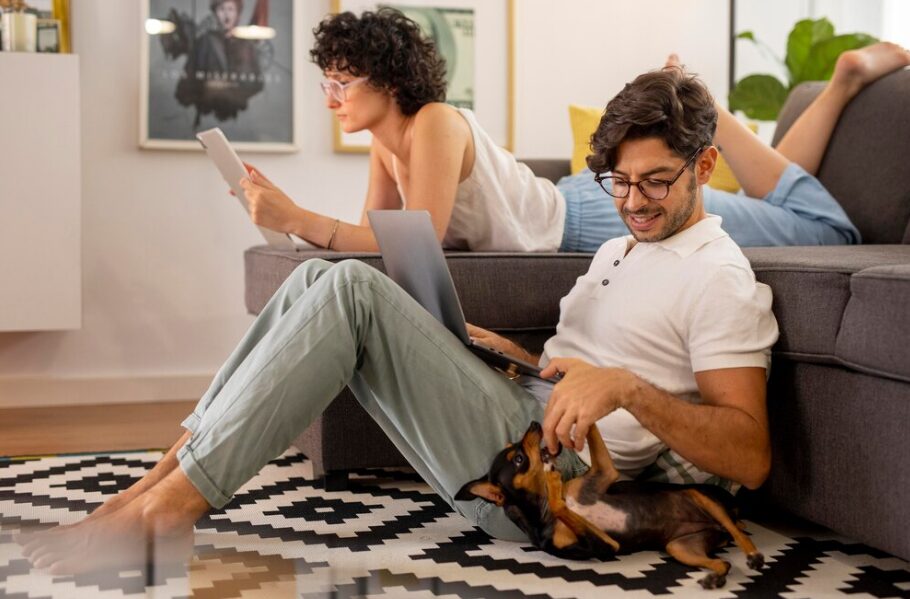 Tutores brincando com seu pet em apartamento.